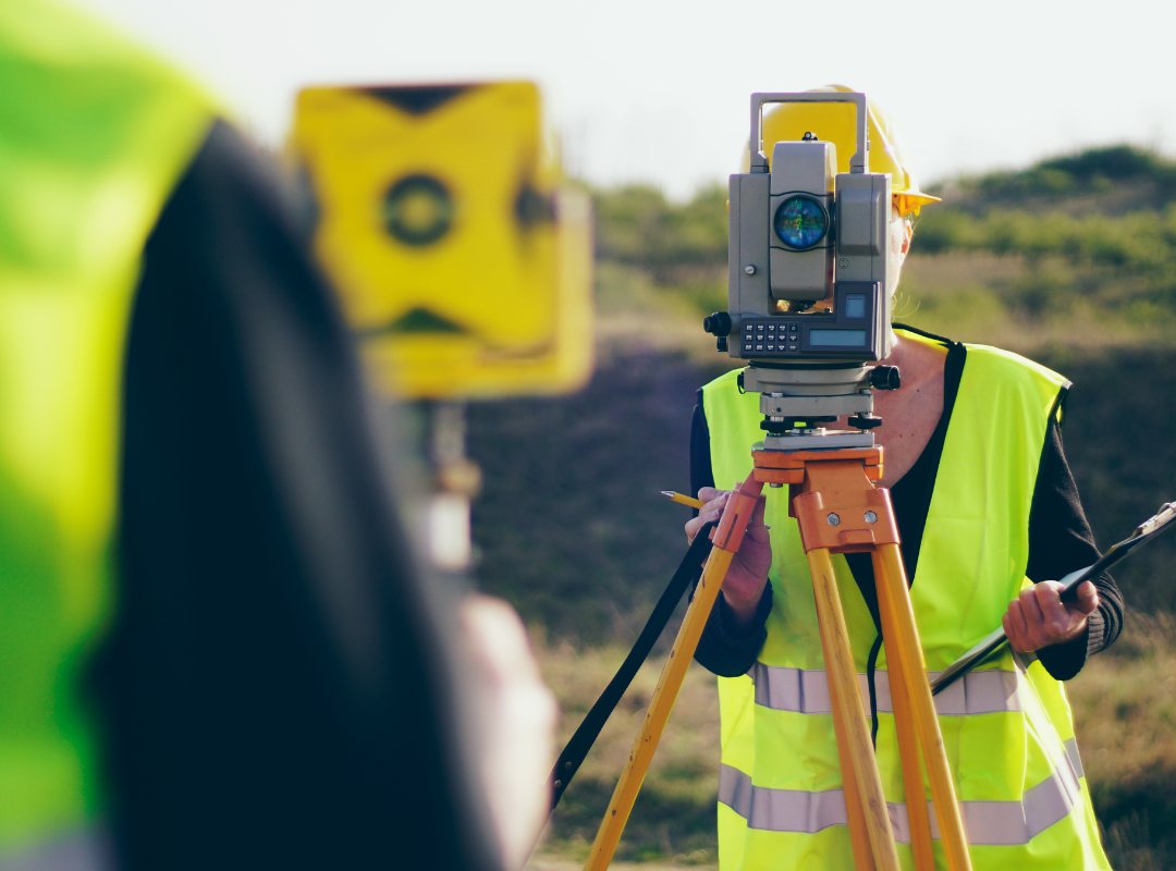 Surveyor using a total station on site